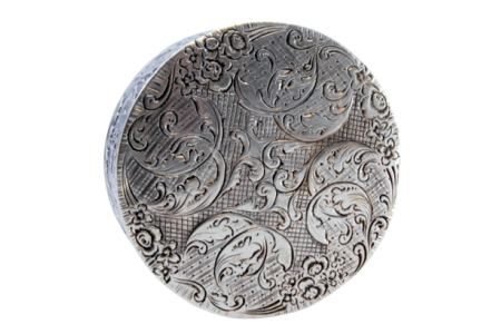 Caixa de comprimidos em prata relevada com motivos florais de forma redonda e tampa basculante.